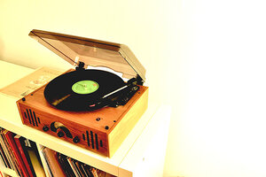 En grammofonspelare för LP-skivor som står på en låg bokhylla.