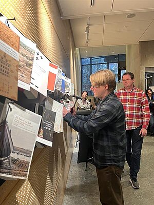 Simon Halberg spikar sin avhandling på spikbrädan. Foto.