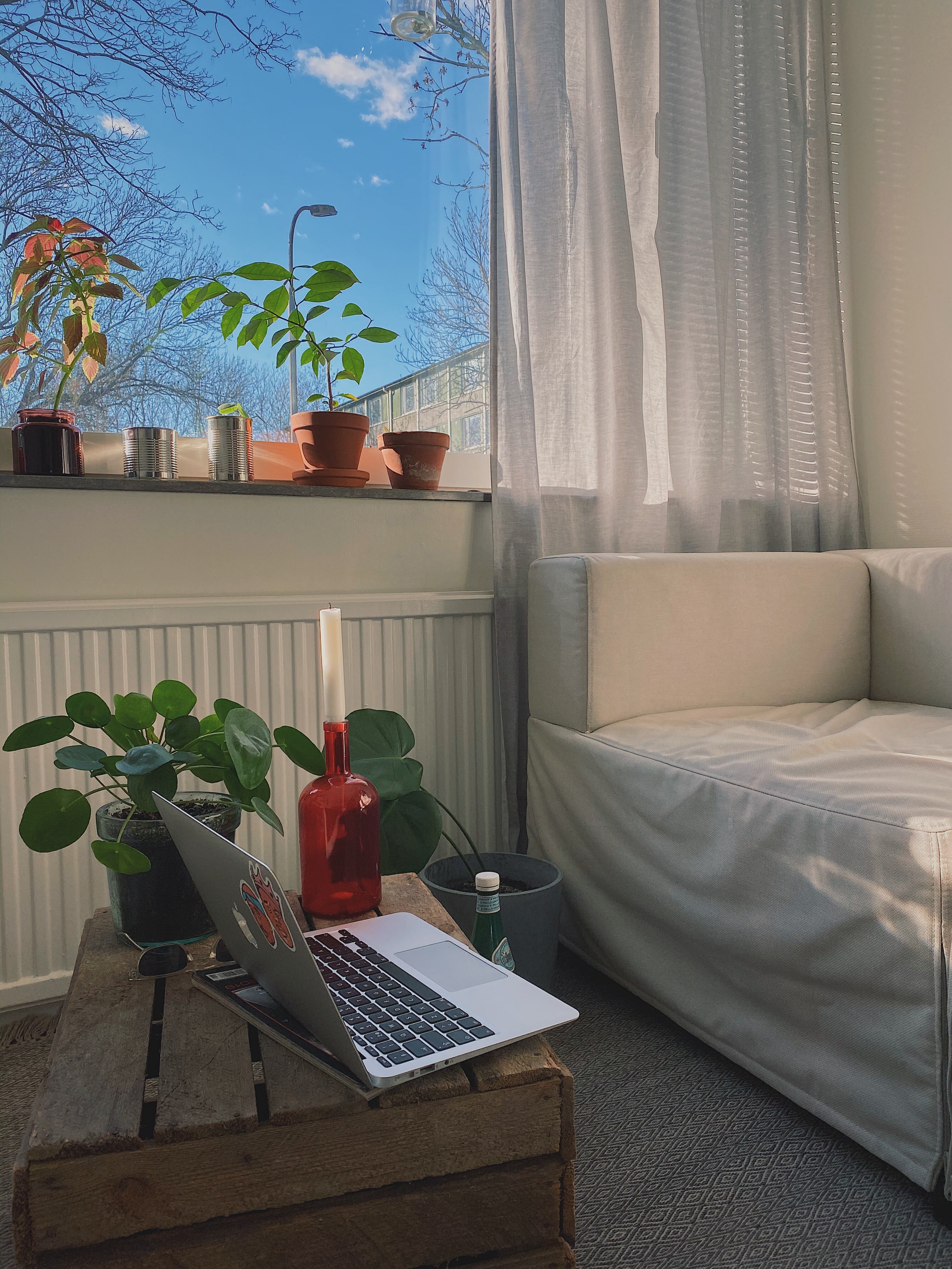 Dator på ett bord framför en soffa.
