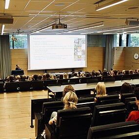 Studenter i sal lyssnar till en presentation. Foto.