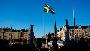 En vy över en stad och en svensk flagga i centrum.