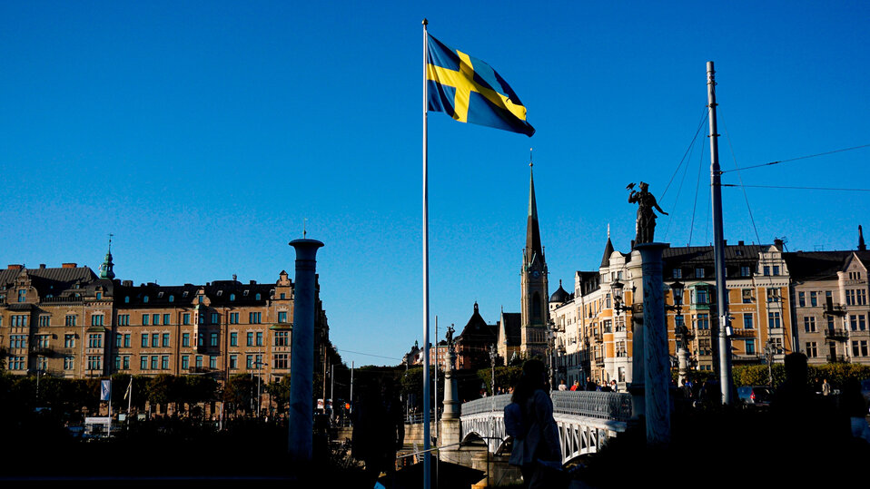 En vy över en stad och en svensk flagga i centrum.