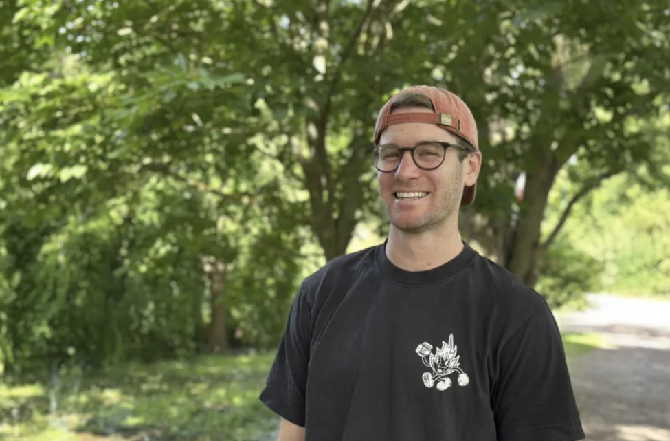 Portrait of Billy Jones in front of green bushes. Foto.