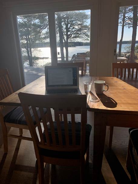 Studieplats vid ett bord framför ett fönster med utsikt över sjö.